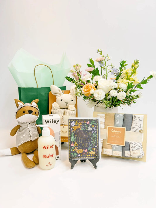 Baby gift set with stuffed animals, flowers, and baby products 