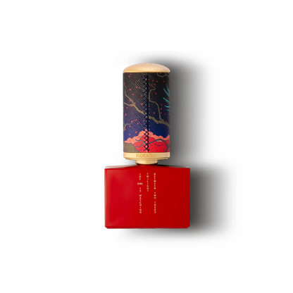 Red perfume bottle with a patterned cap on a white background